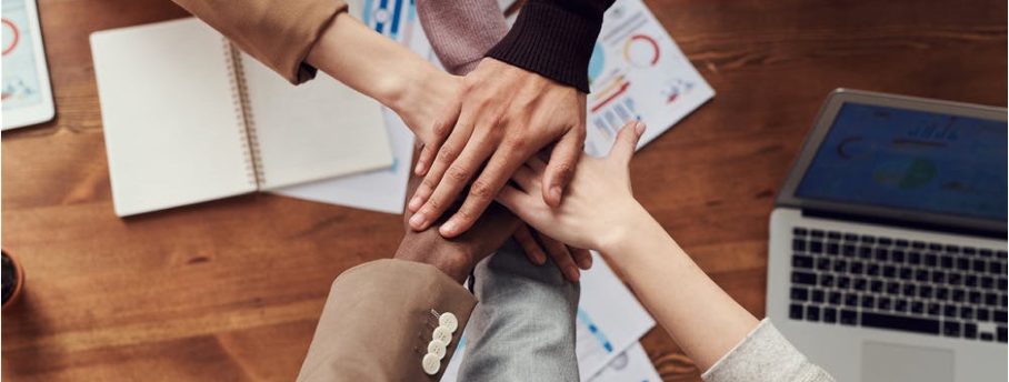 Mains qui se regroupent et qui reflètent la collaboration entre collaborateurs